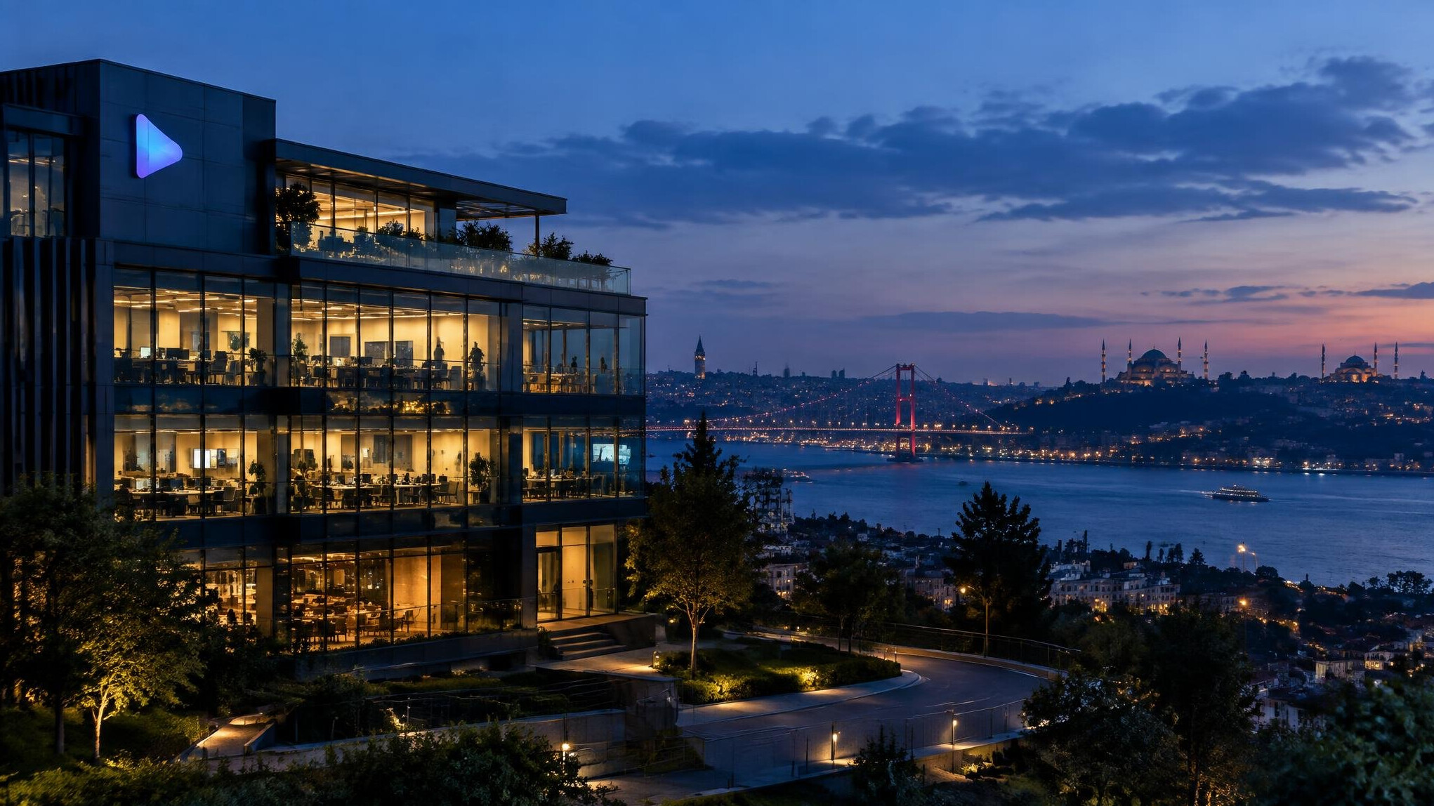 Modern media company building exterior at dusk with lit windows and city skyline